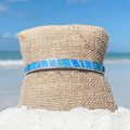 Opal Cuff Bracelet displayed by being wrapped around a canvas cloth with a blurred beach background.