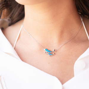 Opal Dolphin Duo Necklace worn around a woman's neck.