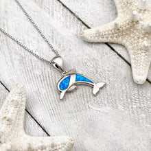 Load image into Gallery viewer, Opal Dolphin Necklace displayed on a white wooden surface.