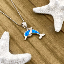 Load image into Gallery viewer, Opal Dolphin Necklace displayed on a wooden surface.
