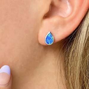 Opal Droplet Stud Earring displayed by being worn on a woman's ear.
