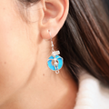 Opal Floatie Girl Earrings displayed by being worn on a woman's ear.