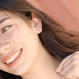 Opal Infinity American Flag Paw Studs is displayed by being worn on a woman's ear.