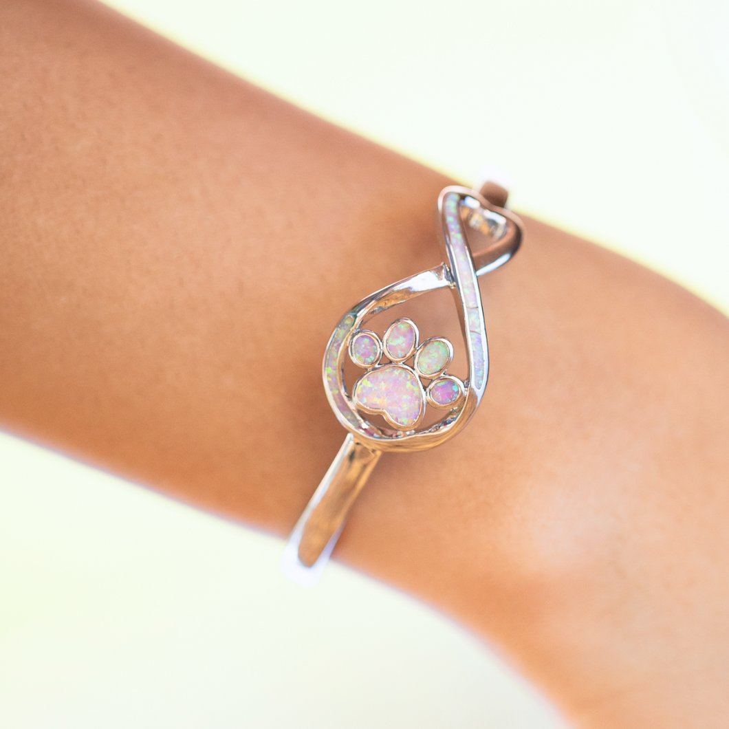 Opal Infinity Love Paw Cuff Bracelet in Pink worn on a woman's arm.