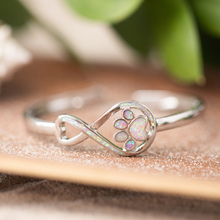 Load image into Gallery viewer, Opal Infinity Love Paw Cuff Bracelet in Pink displayed on a wooden board.