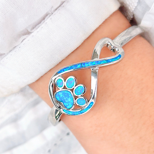 Opal Infinity Love Paw Cuff Bracelet displayed by being worn around a woman's wrist.