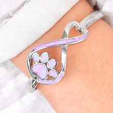 Load image into Gallery viewer, Opal Infinity Love Paw Cuff Bracelet in Pink, worn on a woman&#39;s arm, captured in a close-up shot.