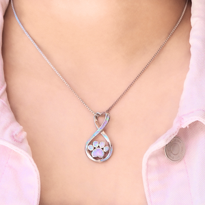 Opal Infinity Love Paw Necklace in Pink displayed closely by being worn around a woman's neck.
