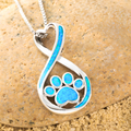 Opal Infinity Love Paw Necklace showcased on a rustic brown rock.