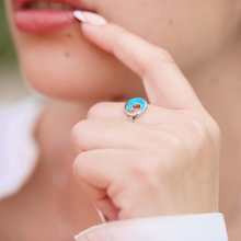 Load image into Gallery viewer, A hand positioned near a woman&#39;s lips is displaying the Opal Rip Curl Ring.