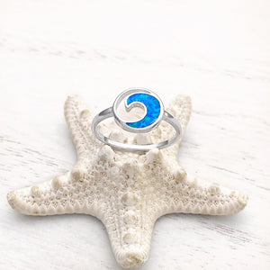 Opal Rip Curl Ring displayed by being placed on top of a white artificial starfish.