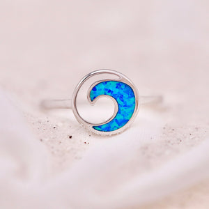Opal Rip Curl Ring displayed on a sandy surface.
