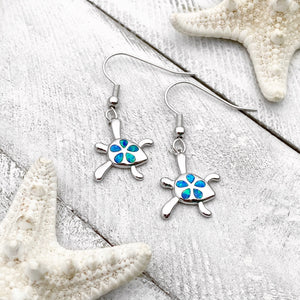 Opal Sea Turtle Flower Earrings displayed on a white wooden surface, ideal for beach-inspired jewelry.
