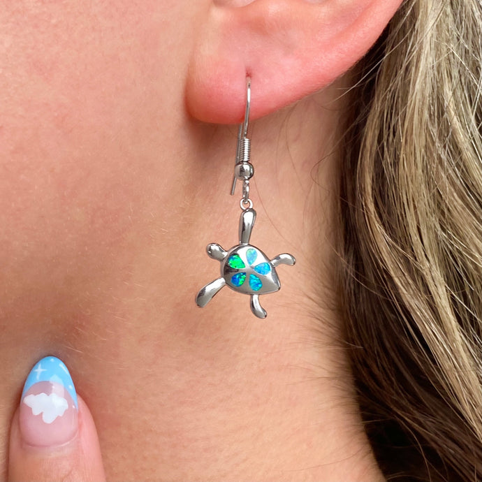 Opal Sea Turtle Flower Earrings worn on a woman's ear, perfect for ocean-themed jewelry.