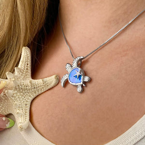 Opal Sea Turtle Starfish Necklace displayed by being worn around a woman's neck.
