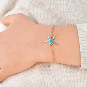 Opal Starfish Bracelet displayed by being worn around a woman's wrist.