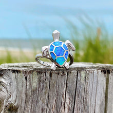 Load image into Gallery viewer, Opal Swimming Sea Turtle Ring is placed on top of a rustic wooden log.