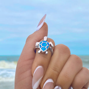 Opal Swimming Sea Turtle Ring displayed closely by worn on a woman's finger.
