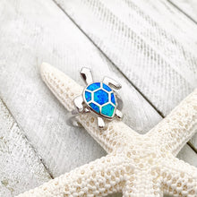 Load image into Gallery viewer, Opal Swimming Sea Turtle Ring displayed by being placed on a dried artificial starfish.