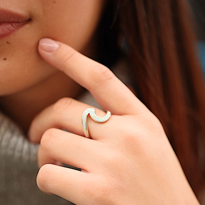 Opal Wave Ring displayed by being worn on a woman's finger.