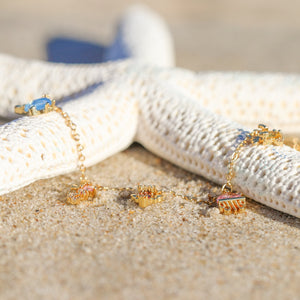 Open Sea Anklet displayed alongside a white dried artificial starfish on the beach.