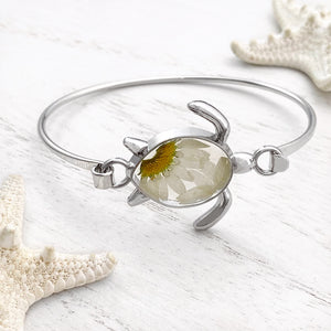 Pressed Daisy Sea Turtle Bracelet displayed on a white wooden surface, ideal spring jewelry.