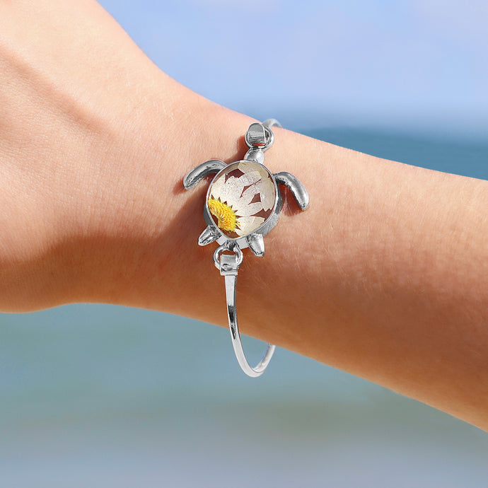 Pressed Daisy Sea Turtle Bracelet worn around a woman's wrist, ideal for beach-inspired jewelry.
