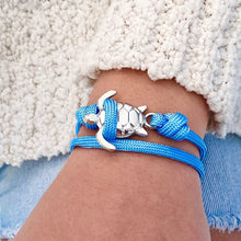 Load image into Gallery viewer, Sky Blue Rope Sea Turtle Bracelet displayed by being worn around a woman&#39;s wrist.