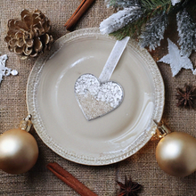 Load image into Gallery viewer, Sand Heart Ornament is showcased by being placed on a center plate with Christmas elements around it.