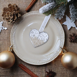 Sand Heart Ornament is showcased by being placed on a center plate with Christmas elements around it.
