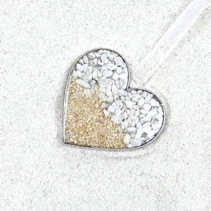 Sand Heart Ornament is displayed on a sandy surface.