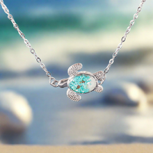 Load image into Gallery viewer, Sand Sea Turtle Anklet hanging close for a shot with a blurred beach background.