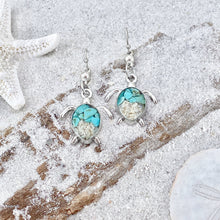 Load image into Gallery viewer, Sand Sea Turtle Earrings are displayed by being placed on top of a sand covered driftwood.