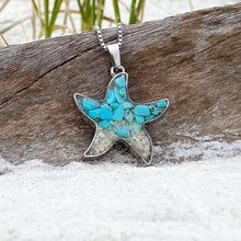 Load image into Gallery viewer, Sand Starfish Necklace in Teal Turquoise is displayed by being placed on top of a driftwood on the sand.