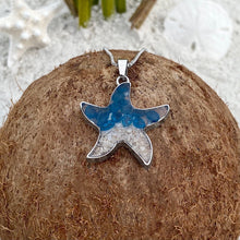 Load image into Gallery viewer, Sand Starfish Necklace in Blue Glass is displayed by being placed on top of a dried coconut.
