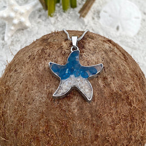 Sand Starfish Necklace in Blue Glass is displayed by being placed on top of a dried coconut.