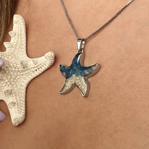 Sand Starfish Necklace in Blue Glass displayed closely by being worn around a woman's neck.