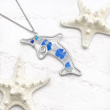 Load image into Gallery viewer, Stacked Sea Glass Dolphin Necklace displayed on a white wooden surface.