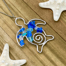 Load image into Gallery viewer, The Stacked Sea Glass Sea Turtle Necklace is displayed on a wooden surface.