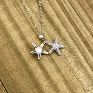 Starfish Hidden Pearl Necklace displayed on a wooden surface.