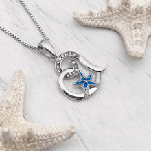 Load image into Gallery viewer, Starfish Love Necklace displayed on a white wooden surface.
