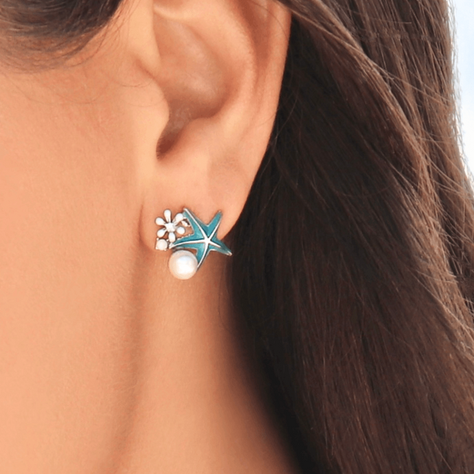 Starfish Pearl Studs displayed up close by being worn on a woman's ear.