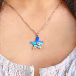 Starfish Sea Turtle Beach Resin Necklace displayed by being worn around a woman's neck.