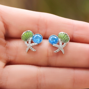 Starfish Shell Studs in Blue showcased on a hand for a close-up view.