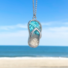 Load image into Gallery viewer, Turquoise Sandy Toes Necklace hanging close for a shot with a blurred beach background.