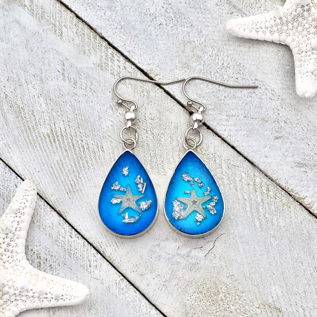 Under the Sea Earrings displayed on a white wooden surface.