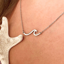 Load image into Gallery viewer, Silver Wave Necklace is displayed up close by being worn around a woman&#39;s neck.