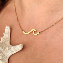 Load image into Gallery viewer, Gold Wave Necklace is displayed up close by being worn around a woman&#39;s neck.