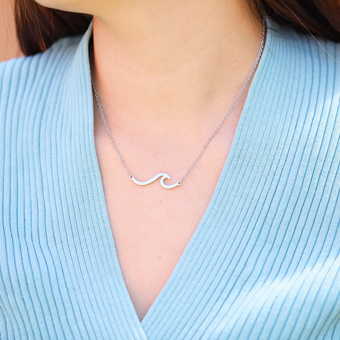 Wave Necklace is displayed by being worn around a woman's neck.