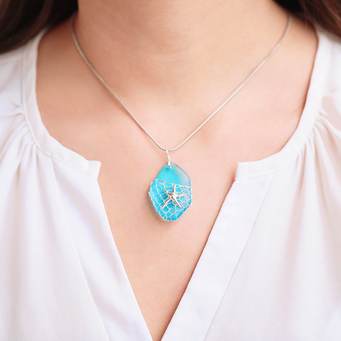 What a Catch Necklace-Ocean Blue is worn around the woman's neck.